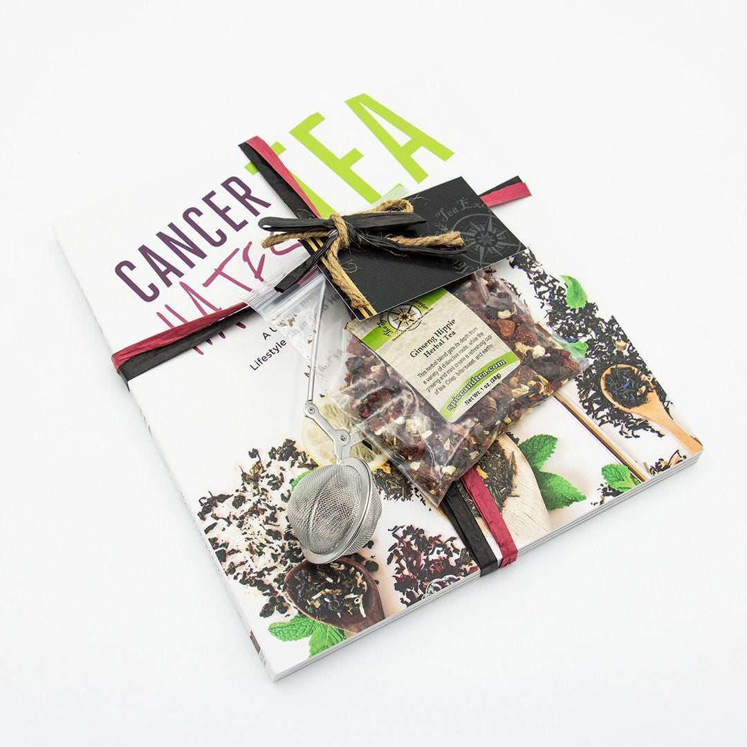 A flat-lay of the Cancer Hates Tea Book & Bundle - Ginseng Hippie, featuring the book, Ginseng Hippie Herbal Tea, a tea infuser, and a black gift tag tied with red ribbon—an ideal gift for tea and wellness fans.